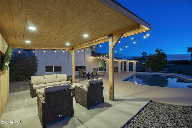 pool at dusk with an outdoor living space and a patio