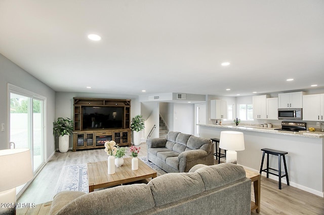 living room with a wealth of natural light and light wood-type flooring