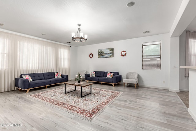 21472 E Saddle Ct, Queen Creek, AZ 85142 - living room featuring a chandelier, light wood-style floors, and baseboards