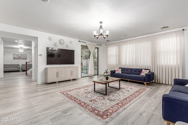 21472 E Saddle Ct, Queen Creek, AZ 85142 - living room featuring a chandelier, light wood-style flooring, stairs, and baseboards