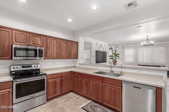 21472 E Saddle Ct, Queen Creek, AZ 85142 - kitchen featuring appliances with stainless steel finishes, a sink, a peninsula, a chandelier, and light countertops