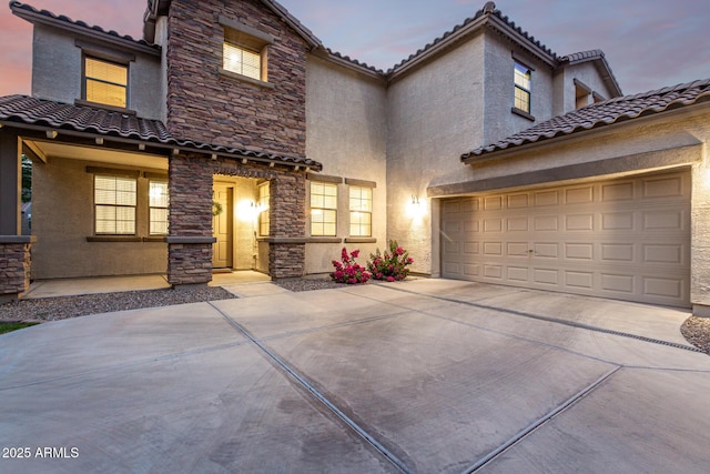 21472 E Saddle Ct, Queen Creek, AZ 85142 - view of front of home with driveway, a tile roof, stucco siding, stone siding, and a garage