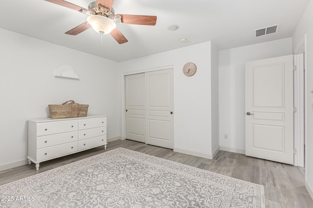21472 E Saddle Ct, Queen Creek, AZ 85142 - bedroom featuring light wood-style floors, baseboards, a closet, and a ceiling fan
