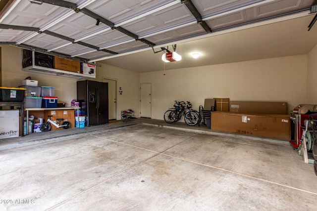 21472 E Saddle Ct, Queen Creek, AZ 85142 - garage with a garage door opener and black fridge with ice dispenser