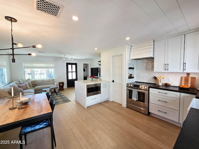 kitchen with custom range hood, visible vents, stainless steel appliances, and open floor plan