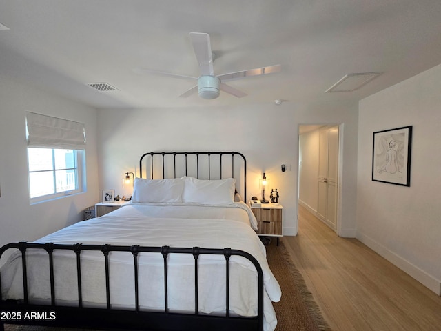 bedroom with light wood-style floors, baseboards, visible vents, and ceiling fan