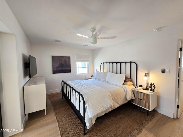 bedroom with baseboards, visible vents, ceiling fan, and wood finished floors