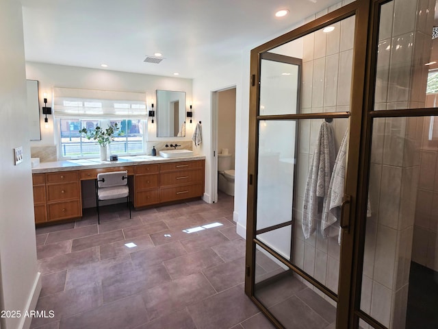 full bathroom featuring toilet, recessed lighting, a sink, visible vents, and double vanity