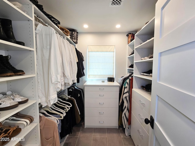 spacious closet featuring visible vents and dark tile patterned flooring