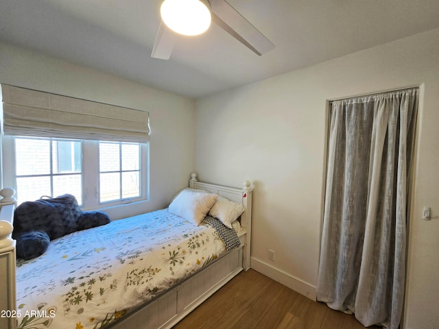 bedroom with a ceiling fan, baseboards, and wood finished floors