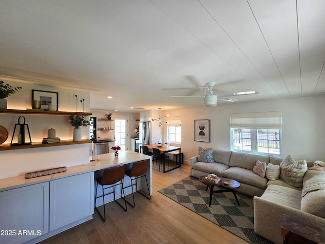 living room featuring ceiling fan and light wood finished floors