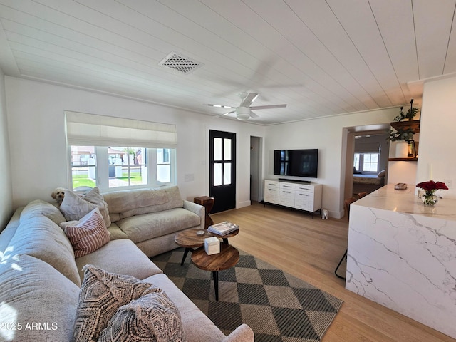 living room featuring light wood-type flooring, a wealth of natural light, and visible vents