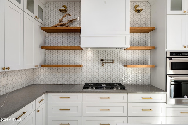 kitchen with decorative backsplash, appliances with stainless steel finishes, and white cabinetry