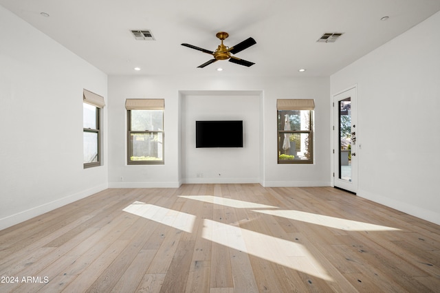 unfurnished living room with plenty of natural light, ceiling fan, and light wood-type flooring