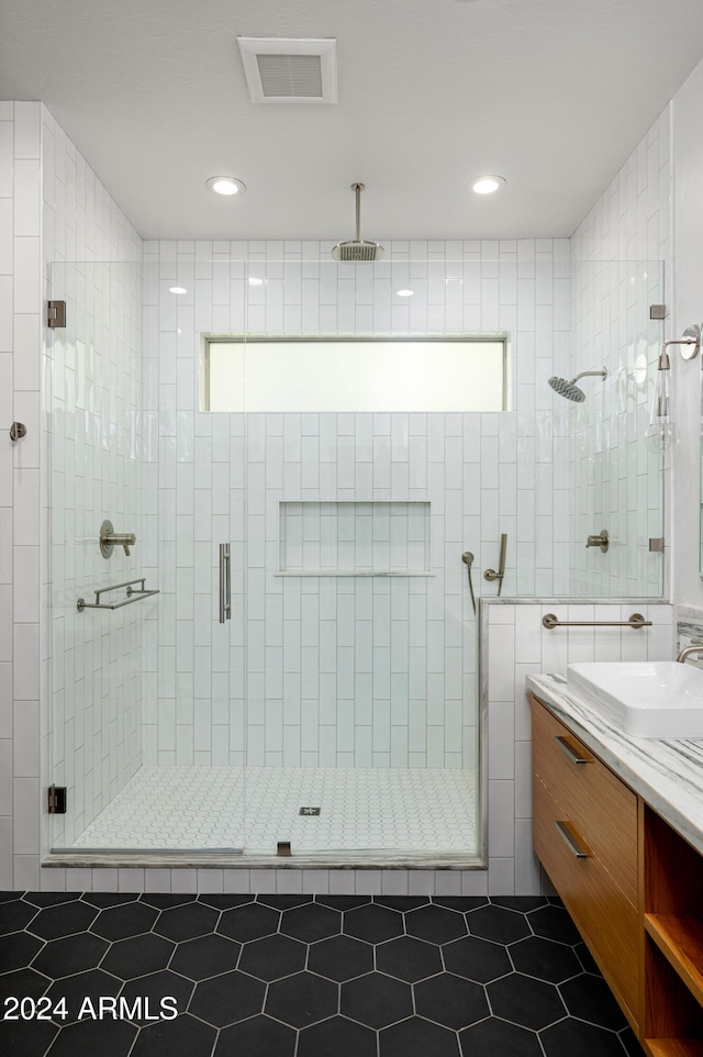 bathroom featuring vanity, tile patterned floors, an enclosed shower, and tile walls