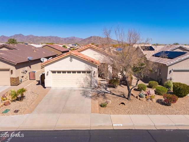 view of front of house featuring a tiled roof, a mountain view, driveway, and stucco siding