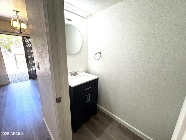 921 W University Dr Unit 1038, Mesa, AZ 85201 - bathroom featuring wood finished floors, a textured wall, a chandelier, baseboards, and vanity