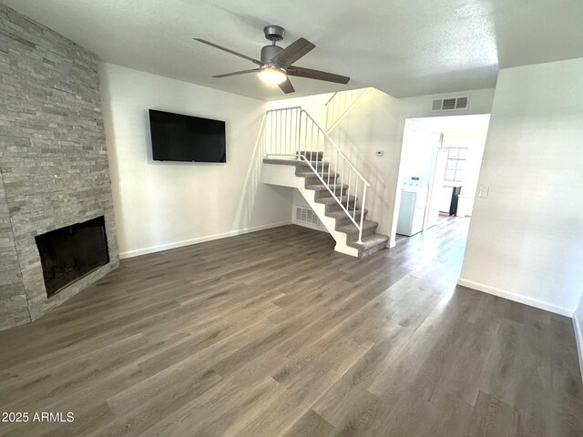 921 W University Dr Unit 1038, Mesa, AZ 85201 - unfurnished living room featuring a ceiling fan, stairs, baseboards, a stone fireplace, and a textured ceiling