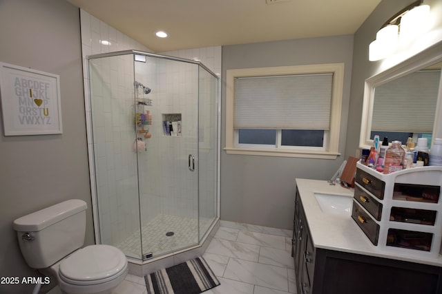 bathroom with a shower with shower door, vanity, and toilet