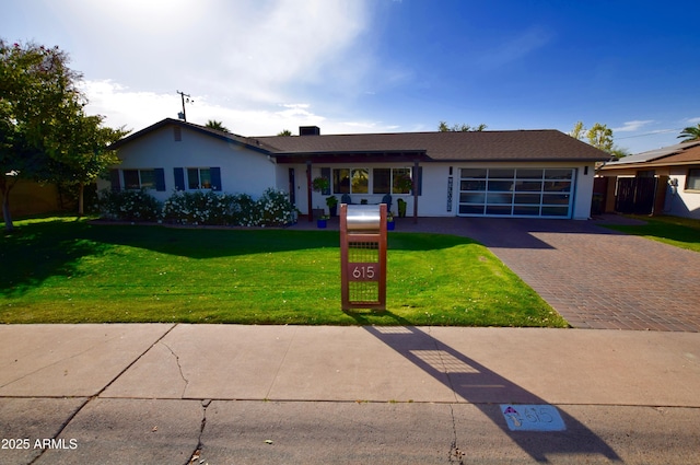 single story home with a garage and a front lawn