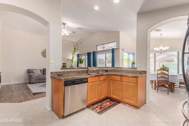 kitchen featuring sink, light tile patterned floors, ceiling fan with notable chandelier, vaulted ceiling, and stainless steel dishwasher