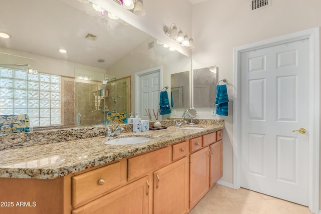 bathroom featuring a shower with door, vanity, and tile patterned floors