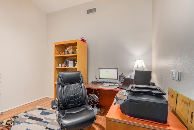 home office with light hardwood / wood-style flooring