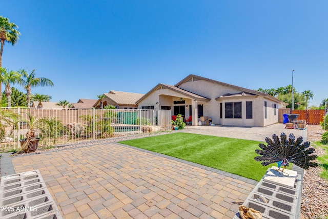 rear view of house featuring a patio area and a lawn