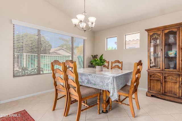 tiled dining room featuring an inviting chandelier and lofted ceiling