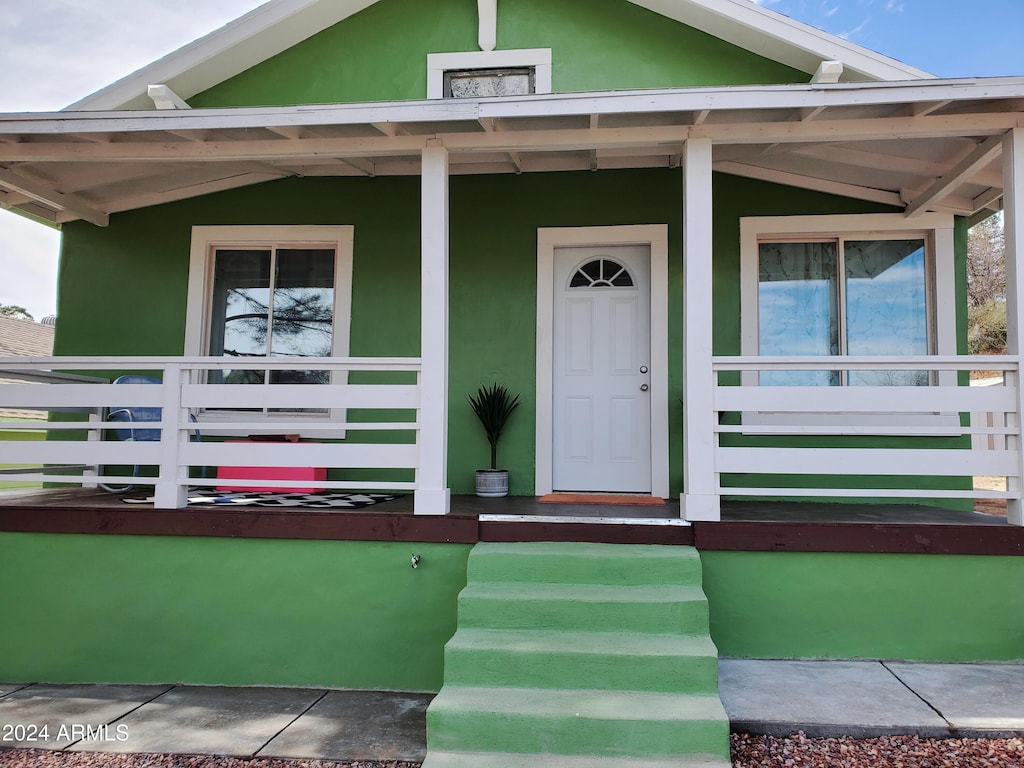 view of exterior entry with covered porch