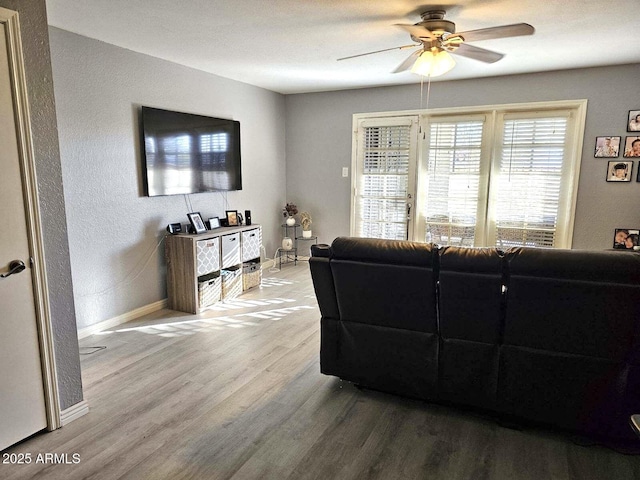 living room with wood-type flooring and ceiling fan