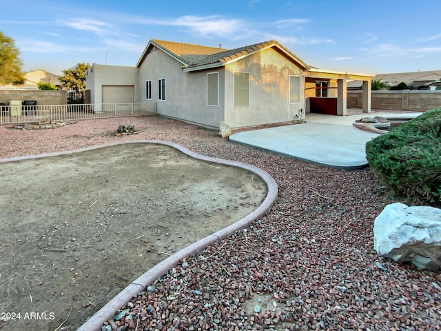 back of house featuring a patio and a garage