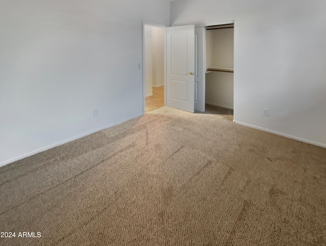 unfurnished bedroom with a closet and light colored carpet