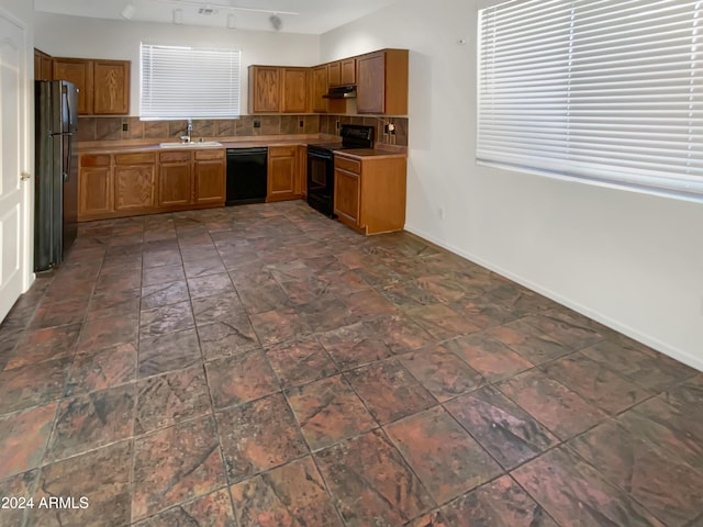 kitchen with black appliances, decorative backsplash, and sink