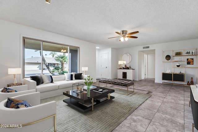 tiled living room featuring a textured ceiling and ceiling fan