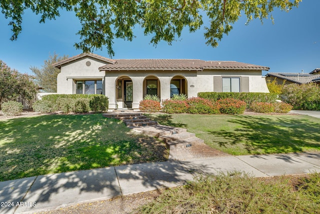 mediterranean / spanish-style house featuring a front yard