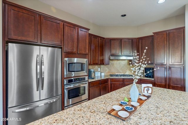 kitchen featuring decorative backsplash, light stone counters, and appliances with stainless steel finishes