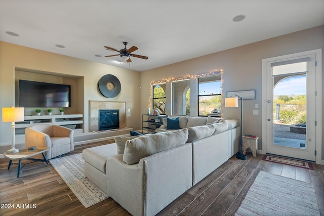 living room featuring ceiling fan, dark wood-type flooring, and a wealth of natural light