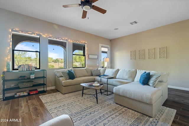 living room with ceiling fan and dark wood-type flooring