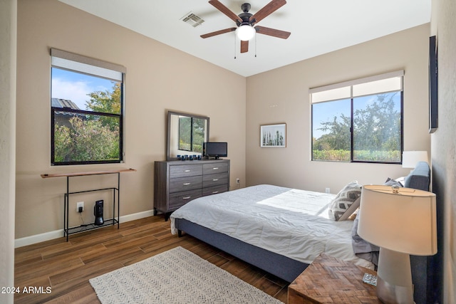 bedroom featuring multiple windows, ceiling fan, and dark hardwood / wood-style floors