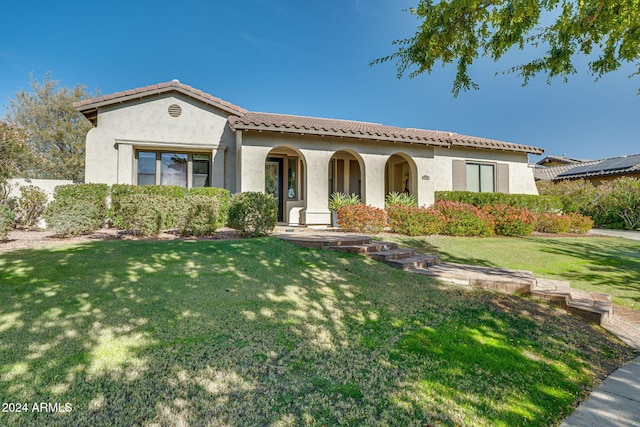 mediterranean / spanish-style home with a front lawn