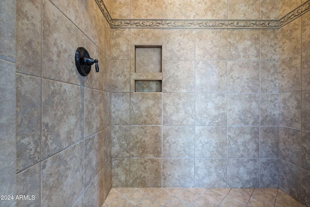 interior details featuring a tile shower