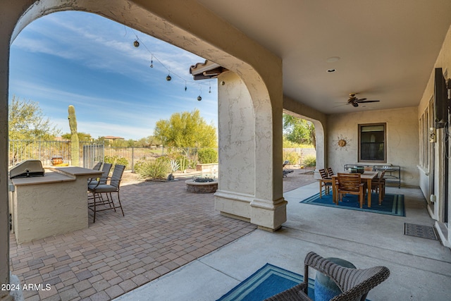 view of patio / terrace featuring an outdoor kitchen, an outdoor bar, ceiling fan, and a grill