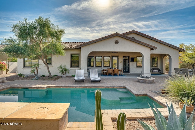 back of property featuring ceiling fan and a patio