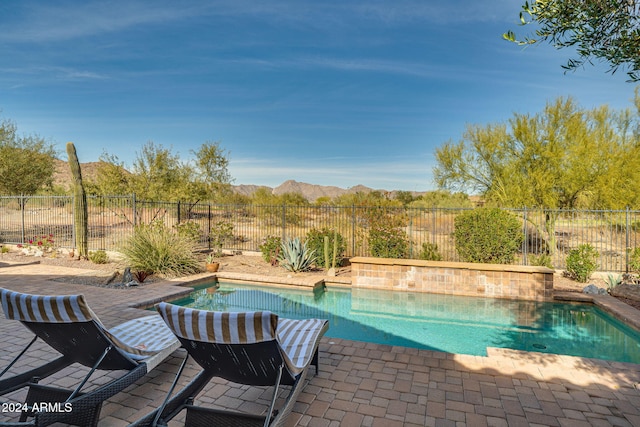 view of pool with a mountain view and a patio