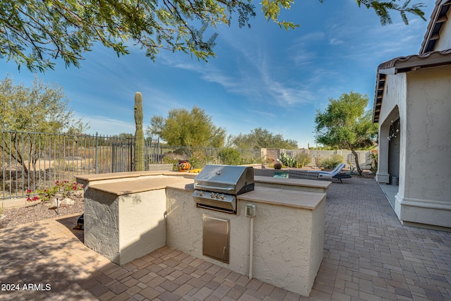 view of patio featuring an outdoor kitchen and a grill