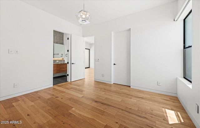 5301 N 43rd St, Phoenix, AZ 85018 - unfurnished bedroom with wood finished floors, connected bathroom, and a chandelier