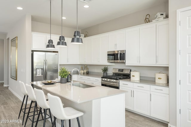 kitchen with white cabinets, light wood-type flooring, sink, and appliances with stainless steel finishes