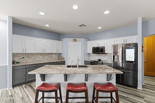 kitchen with gray cabinetry, white cabinetry, sink, and appliances with stainless steel finishes