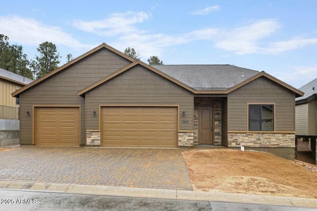 1910 E Rainbow Trl, Payson, AZ 85541 - view of front of home featuring a garage, stone siding, a shingled roof, and decorative driveway